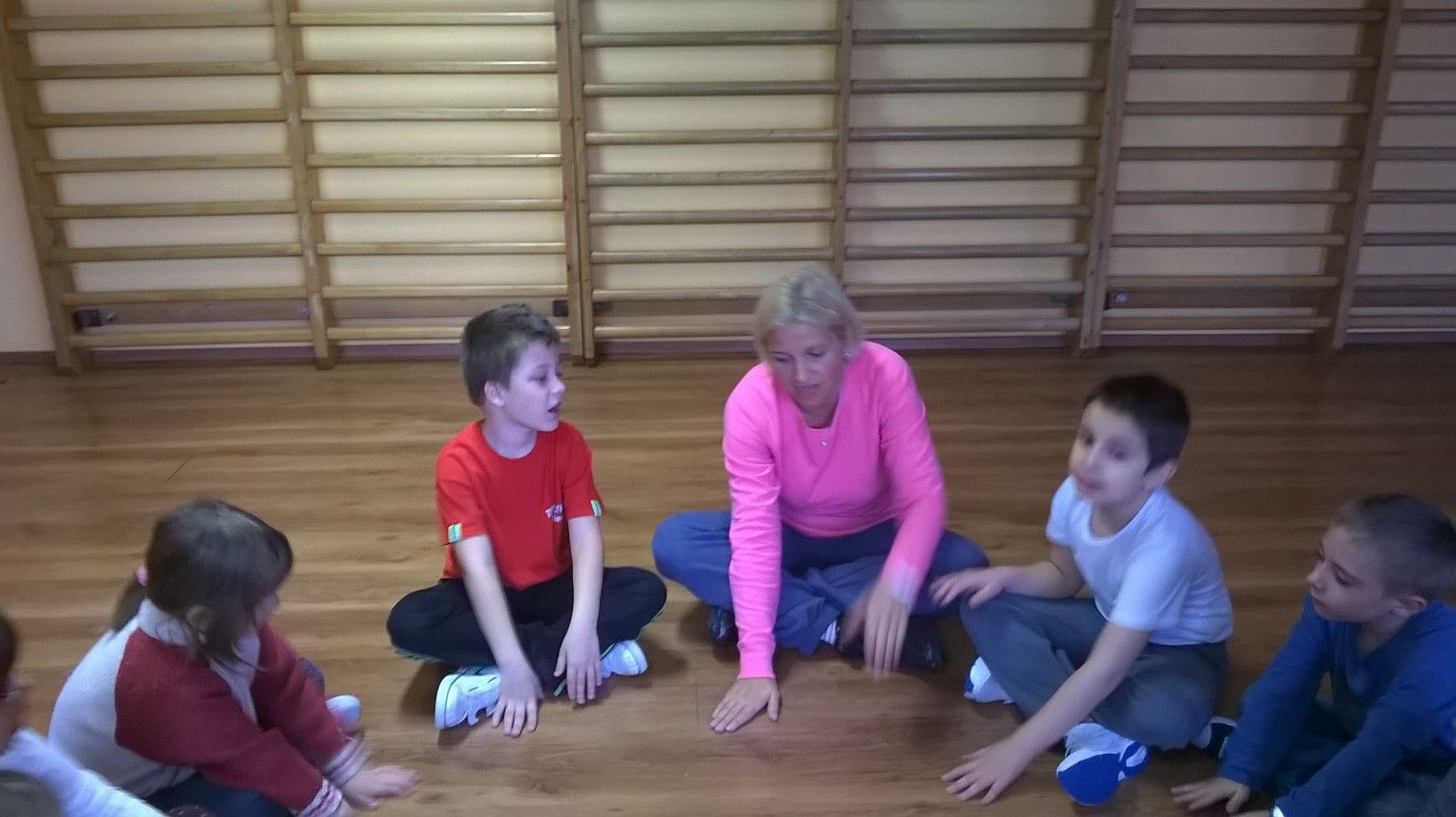 Tammy a padlón ülve beszélget a körben ülő gyerekekkel