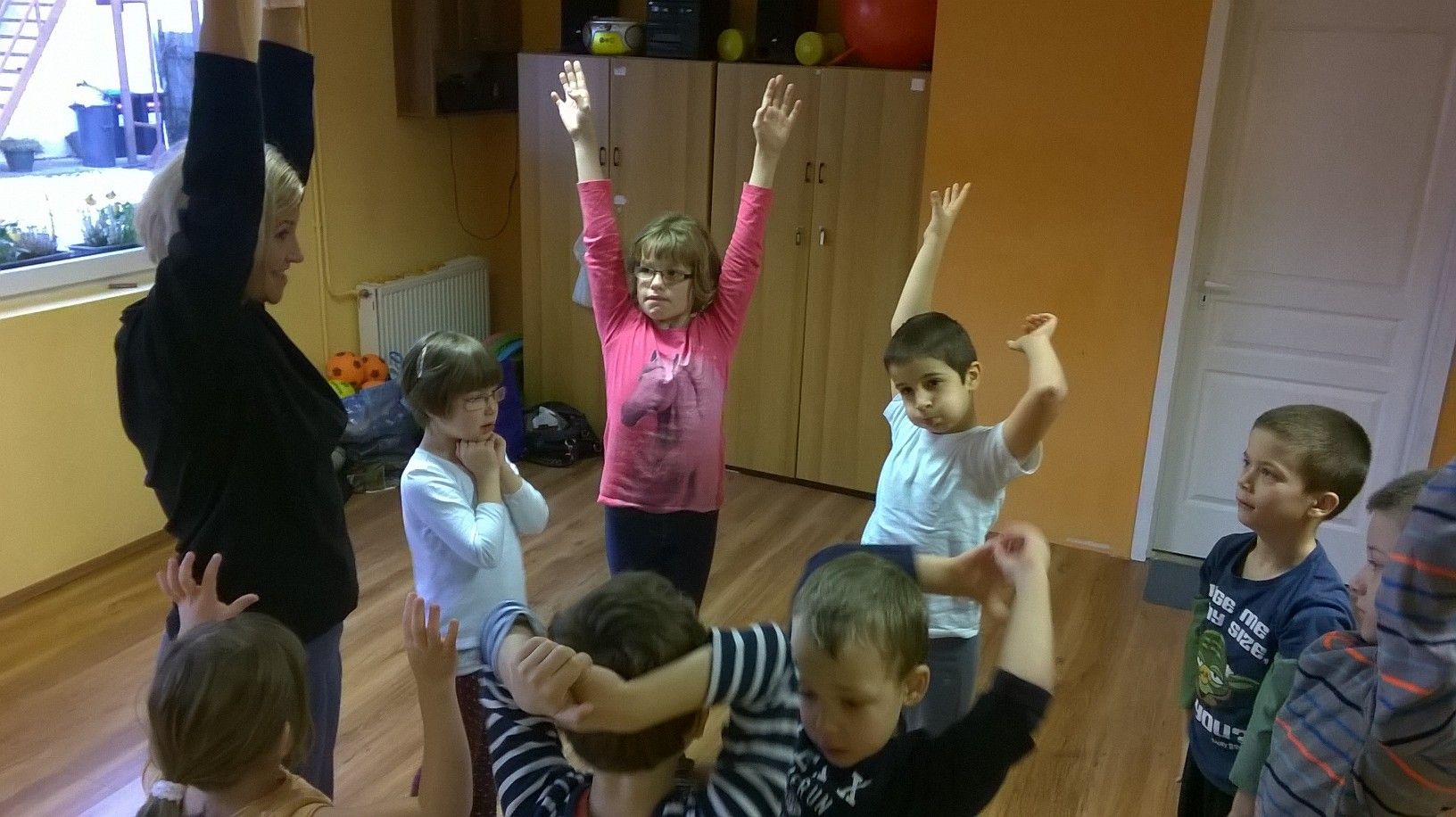 Gyerekek karjukat a magasba nyújtva utánozzák Tammy mozdulatát