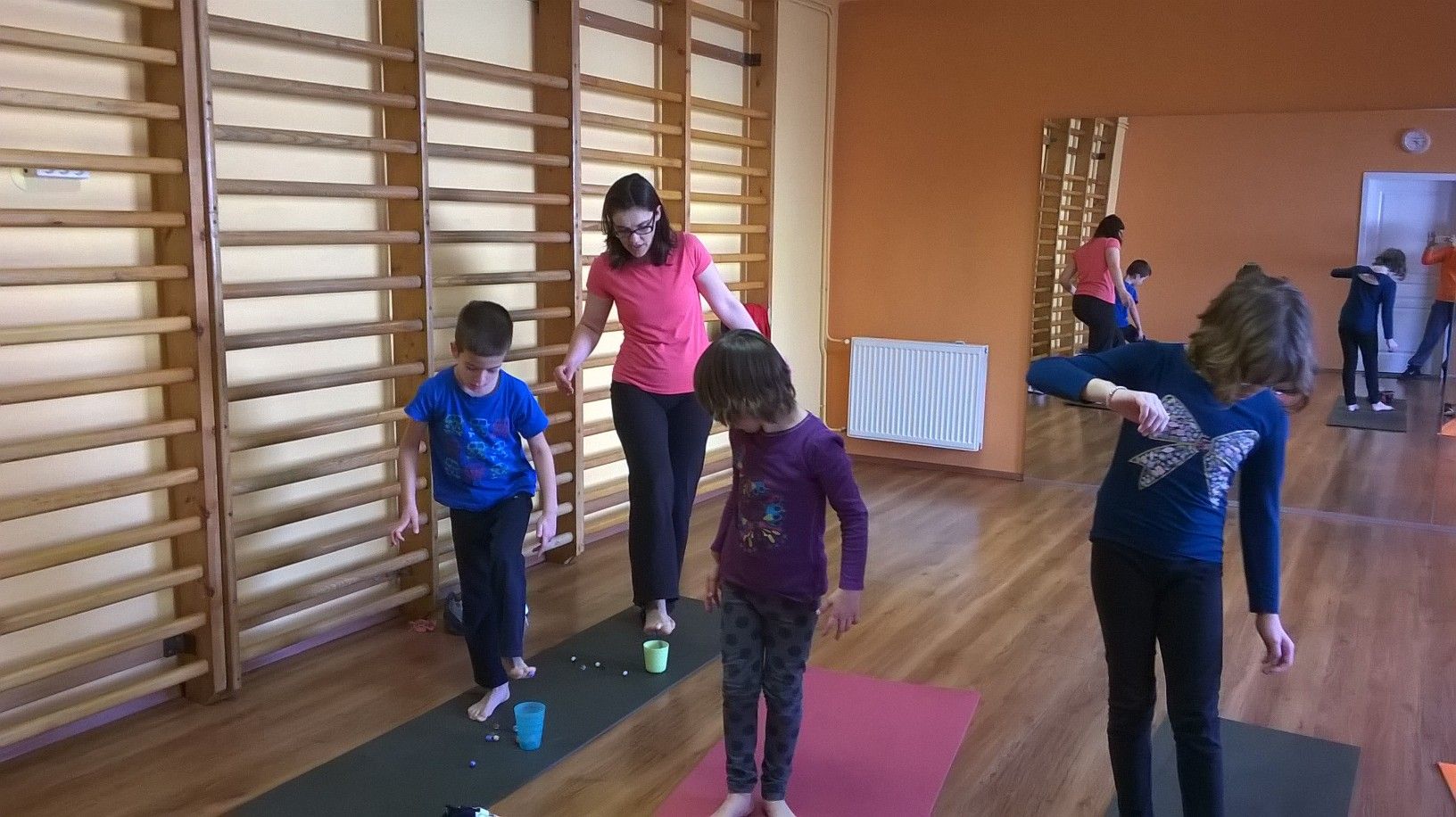 Mezítlábas gyerekek a lábujjukkal apró tárgyakat gyűjtenek poharakba