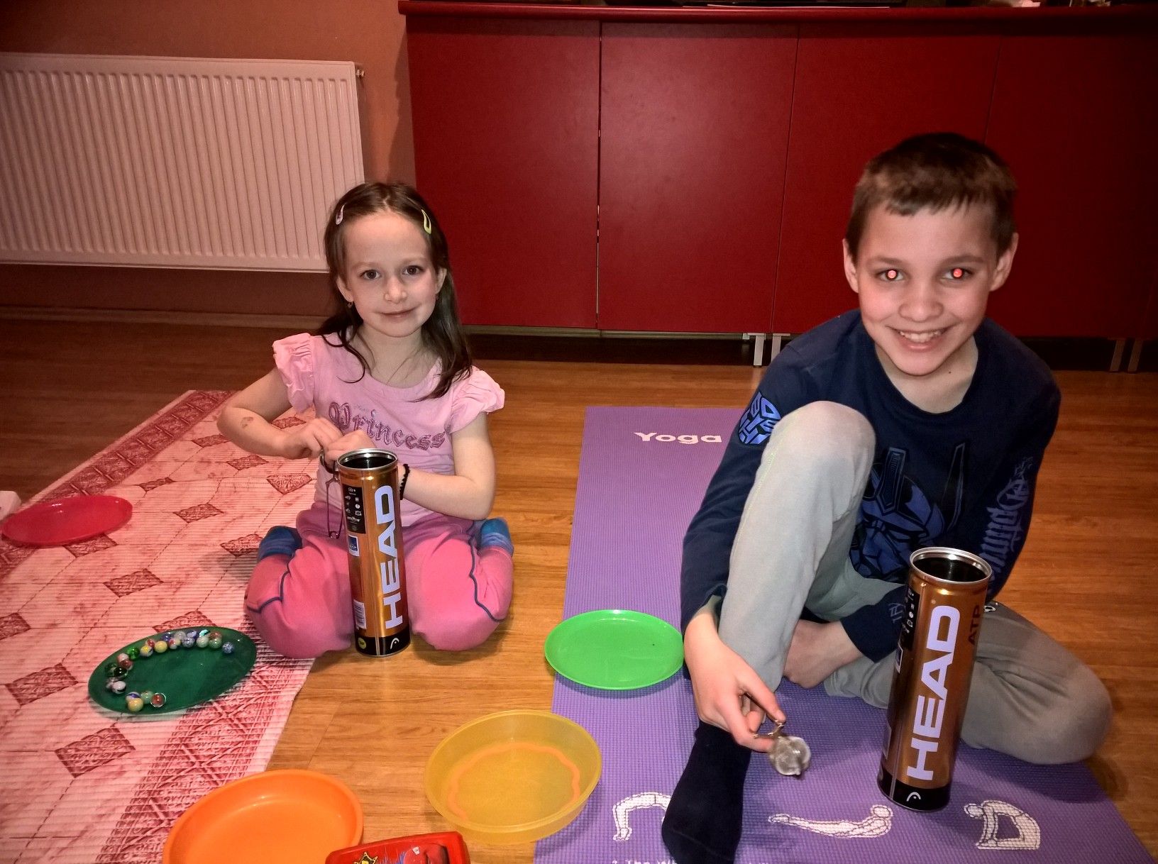 Mosolygó kislány és kisfiú a jógaszőnyegen a válogatós feladat közben