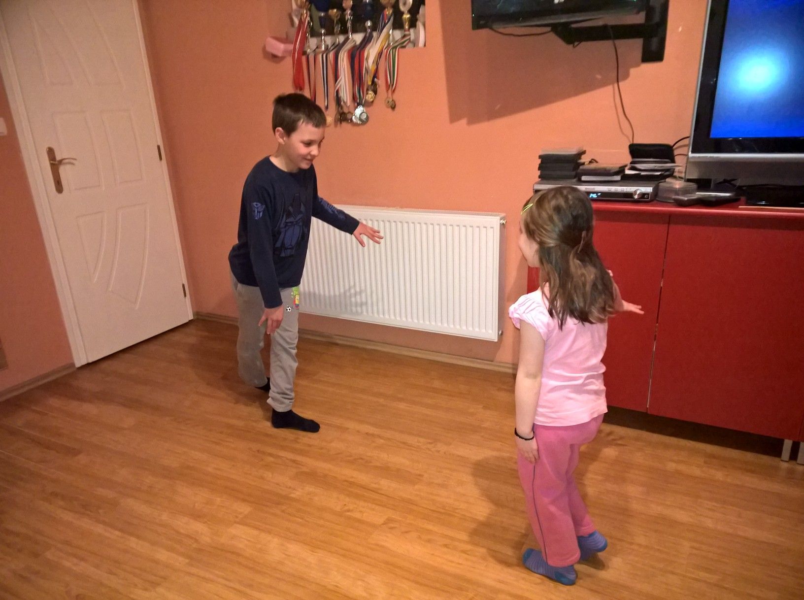 Kisfiú és kislány a szobában mozgásos utánzójátékot játszik